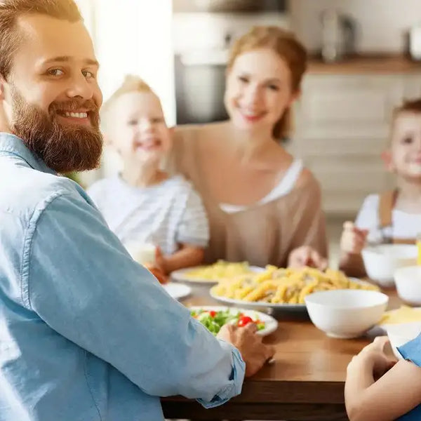 Family of four enjoying a meal together at a dining table.