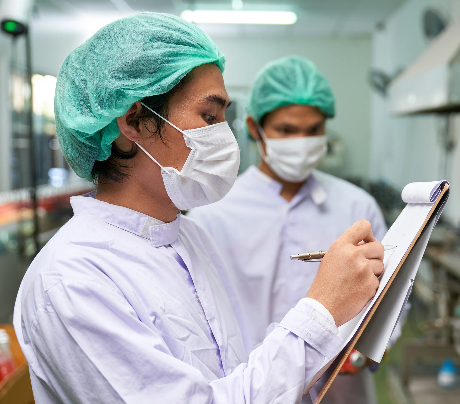 Person in PPE holding a clipboard in a hospital setting