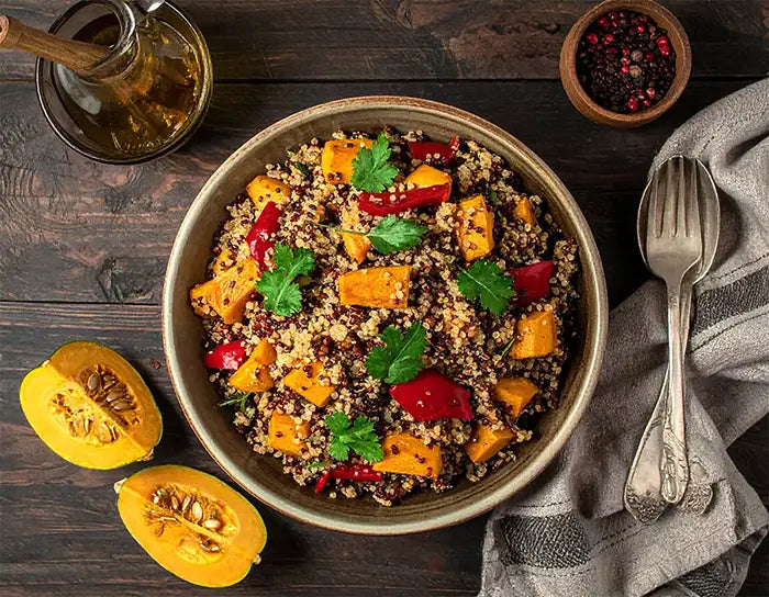 Bowl of quinoa salad with vegetables on a wooden table