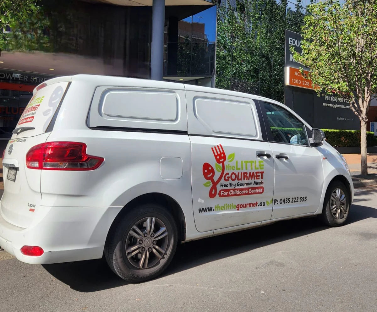 White delivery van with The Little Gourmet branding parked on a street